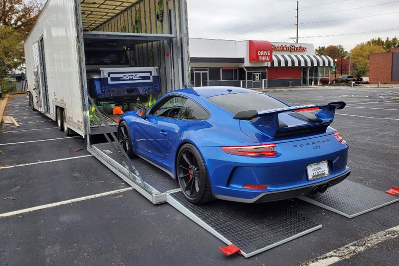 Sports car being loaded into an enclosed carrier