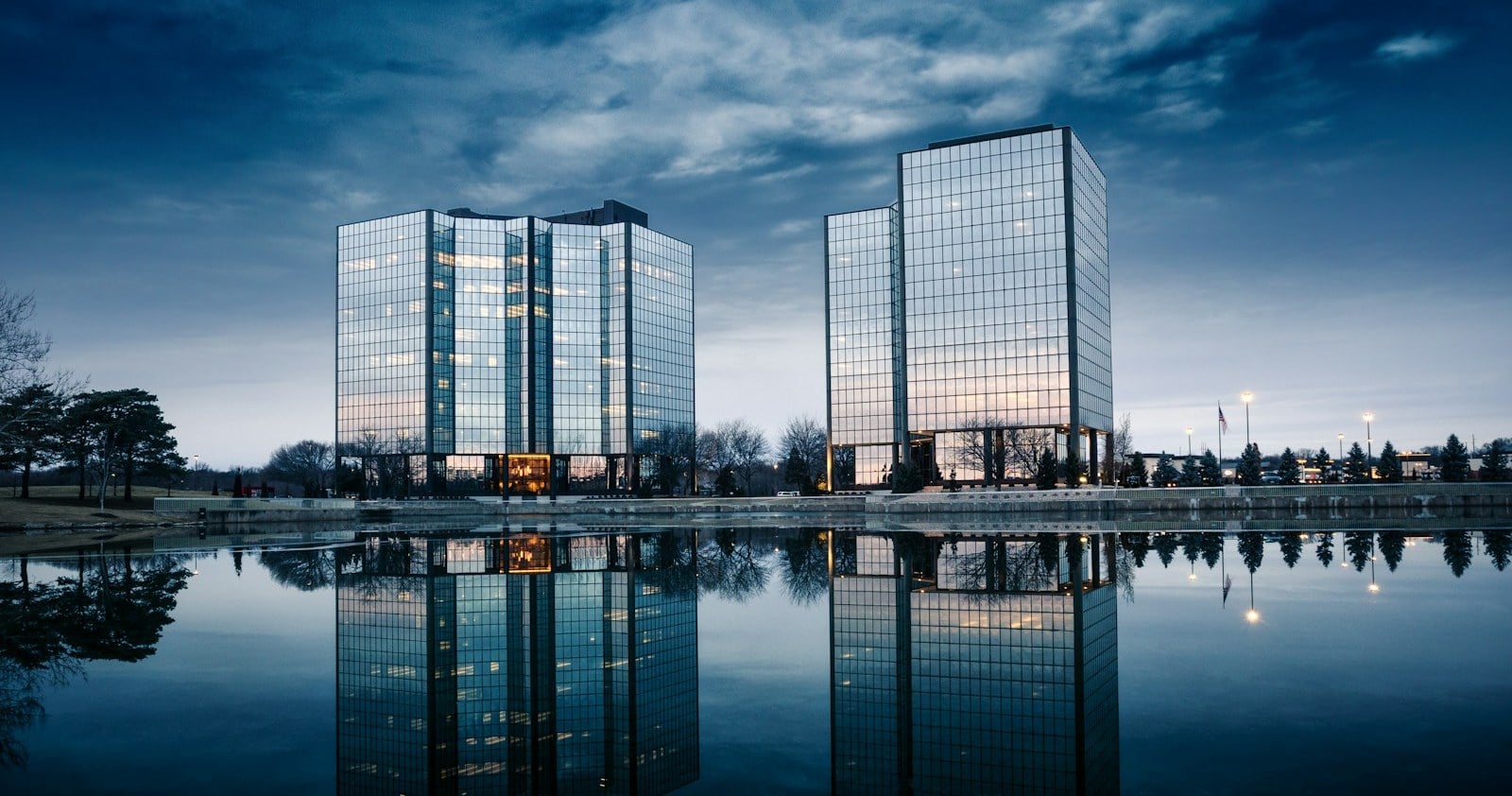Glass office towers reflecting on a pond at dusk in Overland Park, Kansas