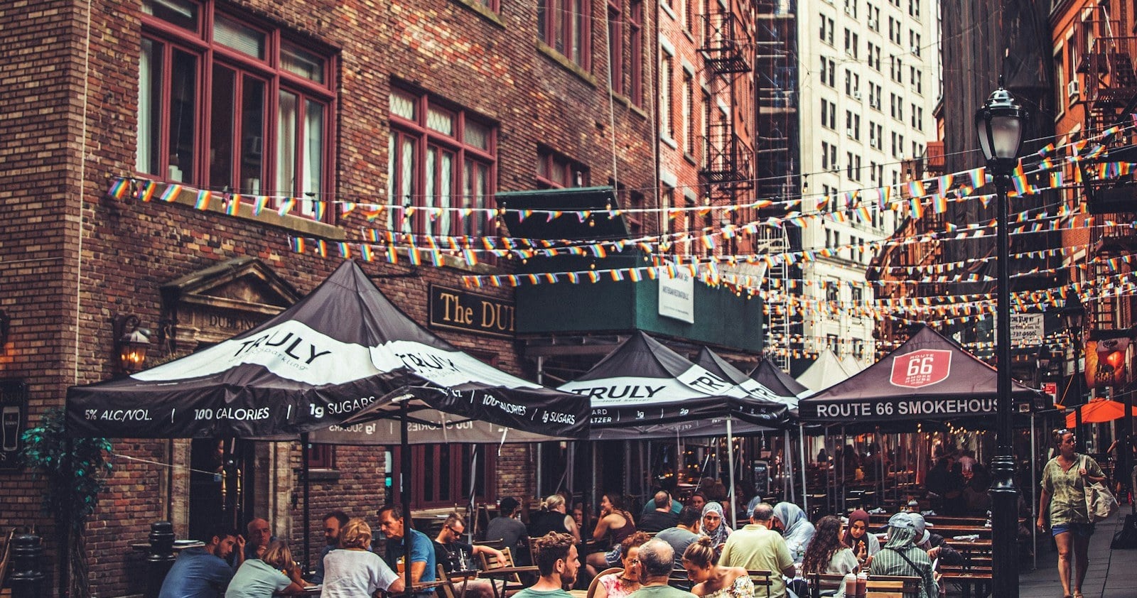 Outdoor dining beside brick mill-era blocks in downtown Lowell, Massachusetts