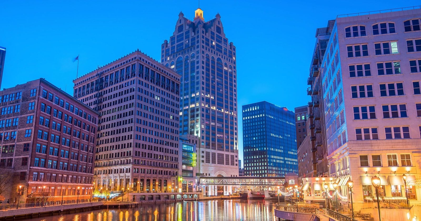 Downtown Milwaukee towers above the Milwaukee River riverwalk at dusk