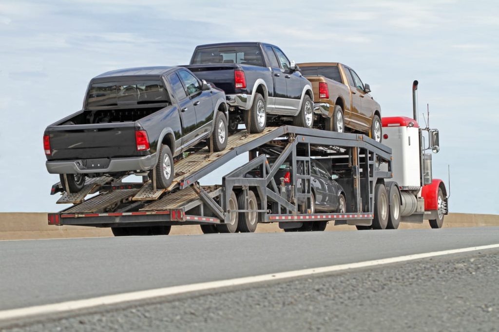 Car hauler loaded with pickup trucks on a highway