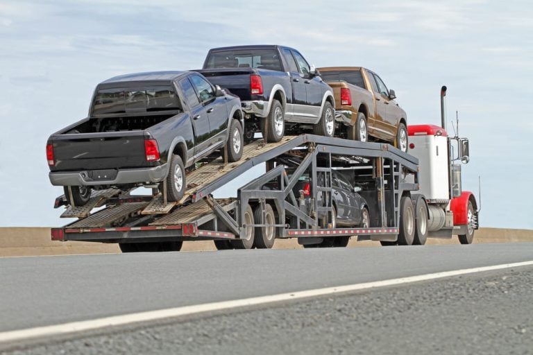 Car hauler loaded with pickup trucks on a highway