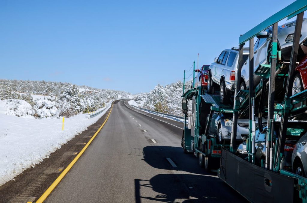 Car carrier on a snowy mountain road