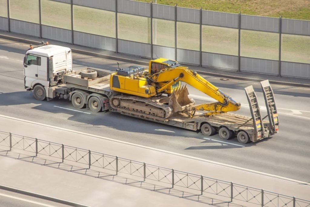Excavator loaded on a trailer for heavy equipment. heavy transport truck