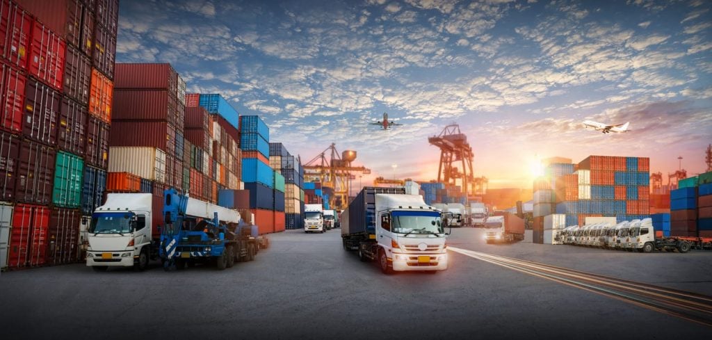 Logistics and transportation of Container Cargo ship and Cargo plane with working crane bridge in shipyard at sunrise, logistic import export and transport industry background