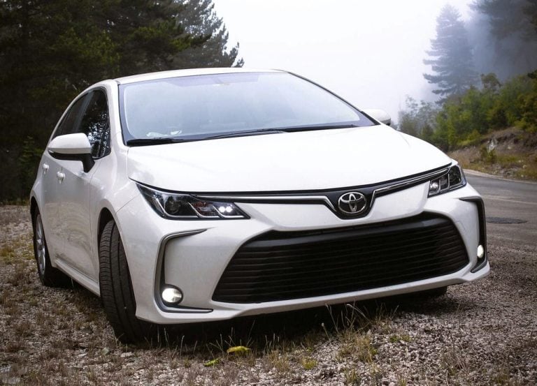 White compact sedan parked on a gravel shoulder