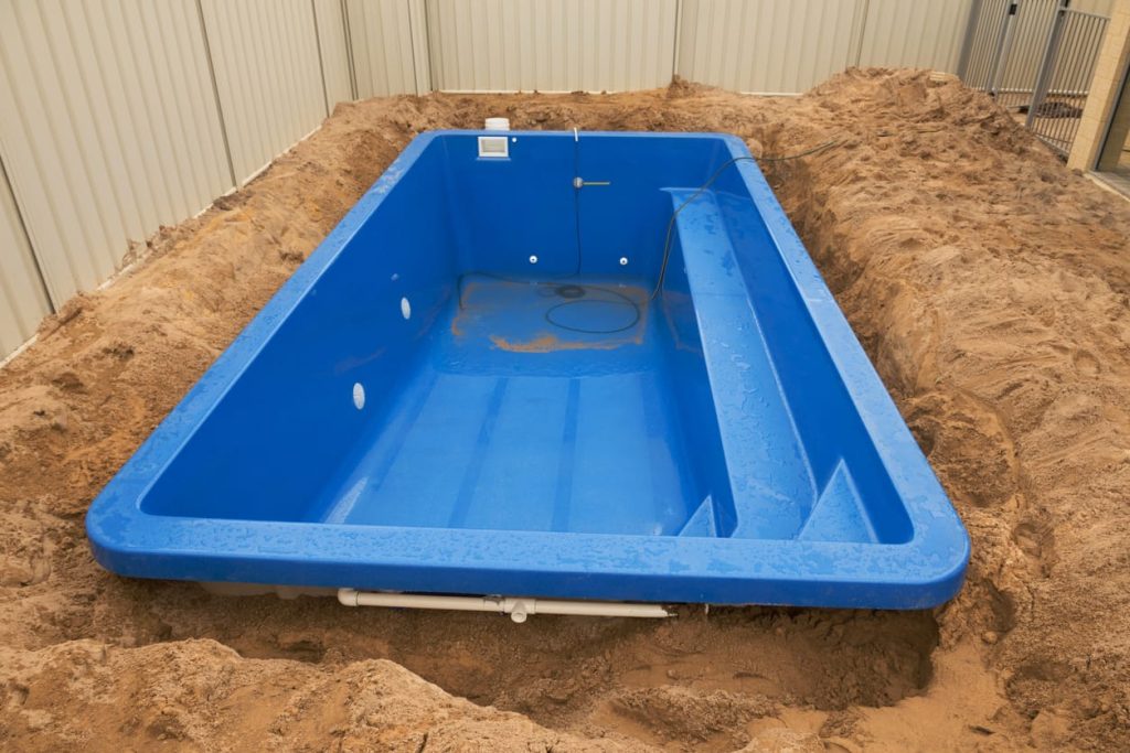 Fiberglass pool shell set in a sand excavation