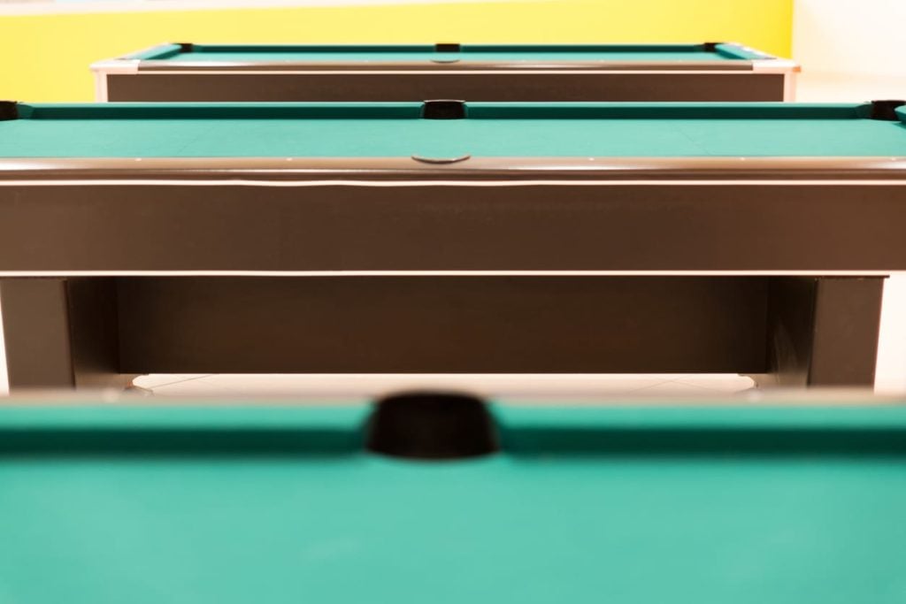 Pool tables in a hall showing the frame and rail construction