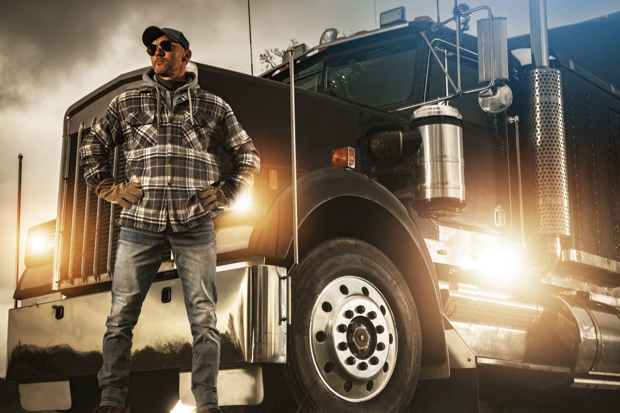 Professional Truck Driver Proudly Standing in Front of His Vehicle Hauler 