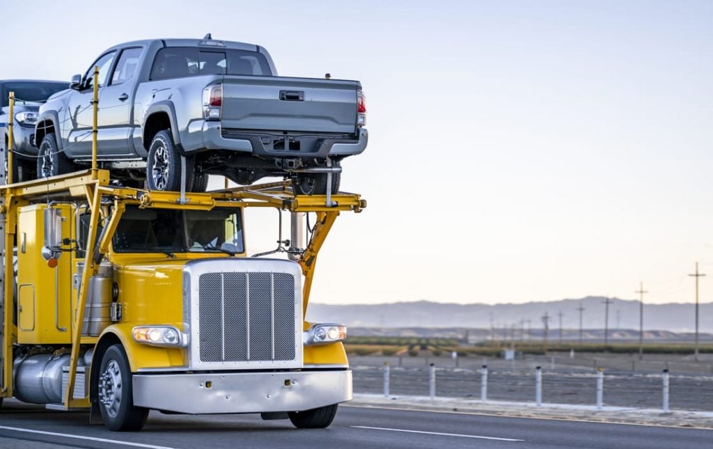 Bright yellow industrial standard big rig car hauler semi