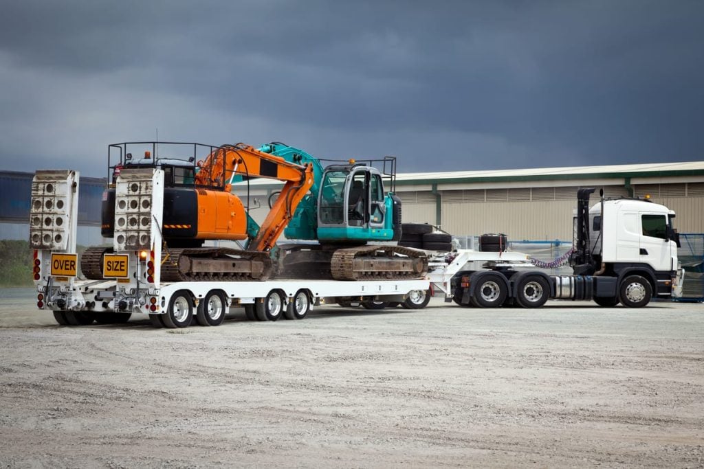 Truck Towing Float Trailer and Hydraulic Excavators