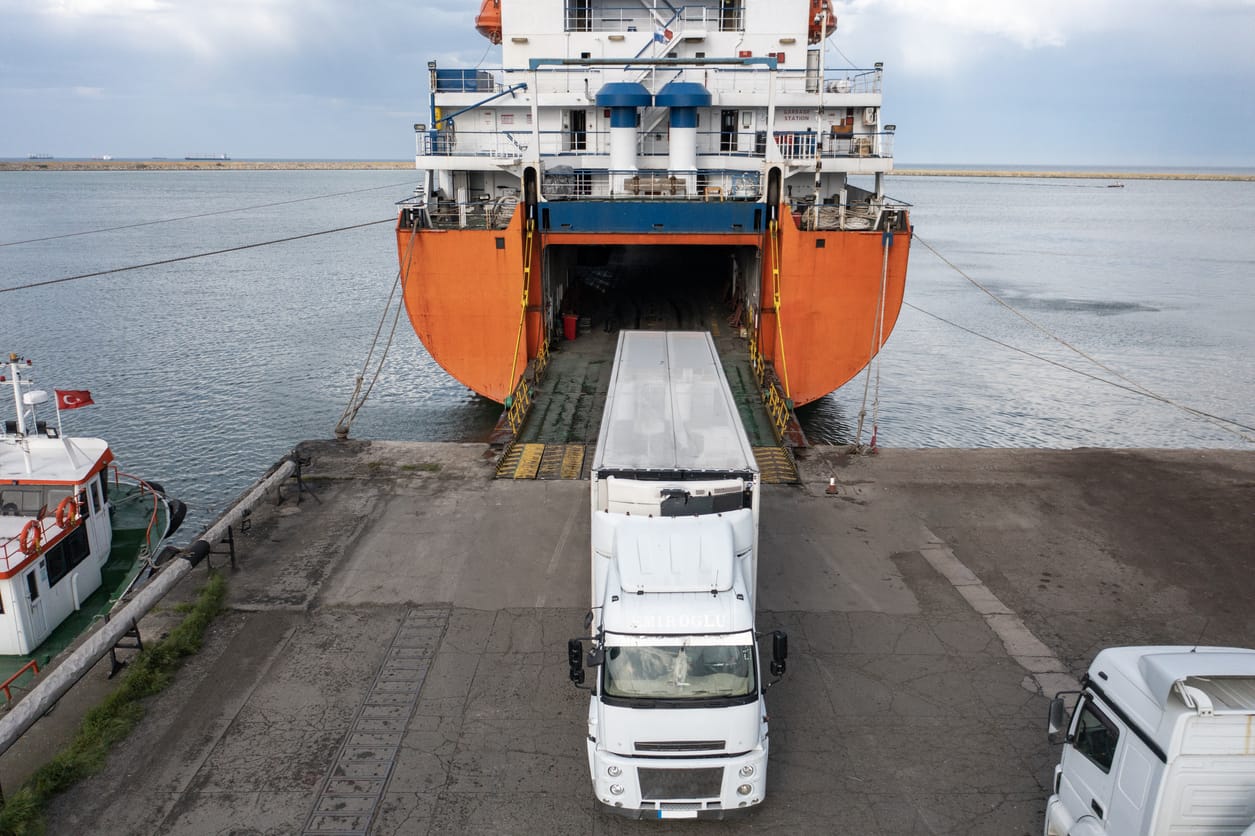 Shipping and Trucking Transportation - RO-RO Transport (Roll On/Roll Off).  Aerial view of Trucks leaving Ro-Ro ship.