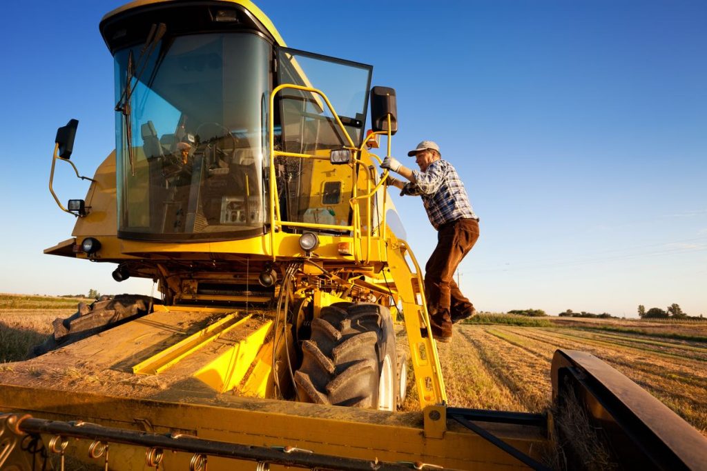 Forage harvester working a field with an operator alongside