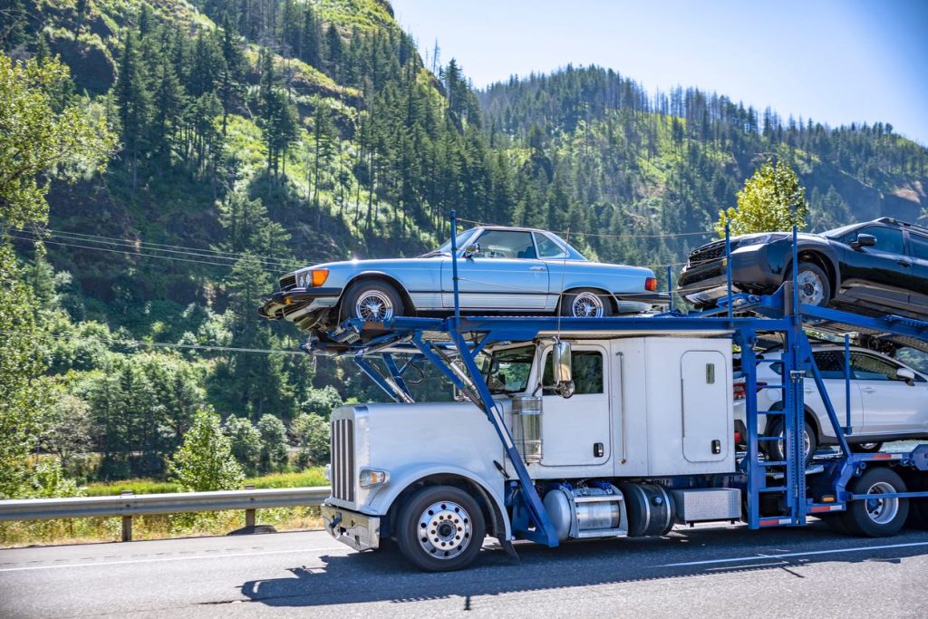 Blue car hauler loaded with vehicles on a highway
