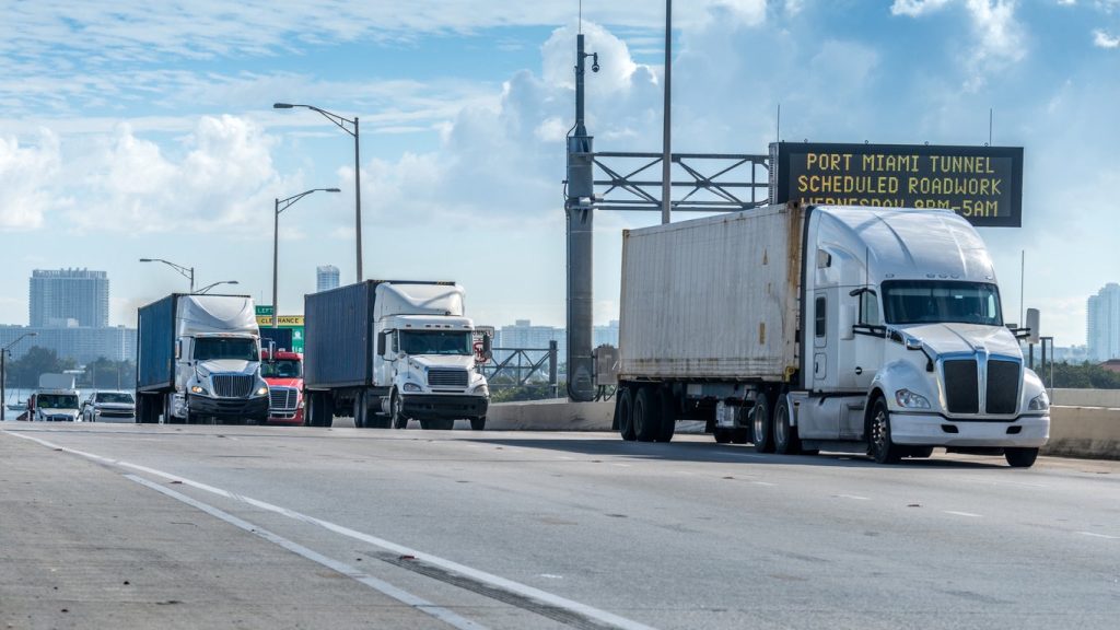 Trucks on a highway approaching a tunnel