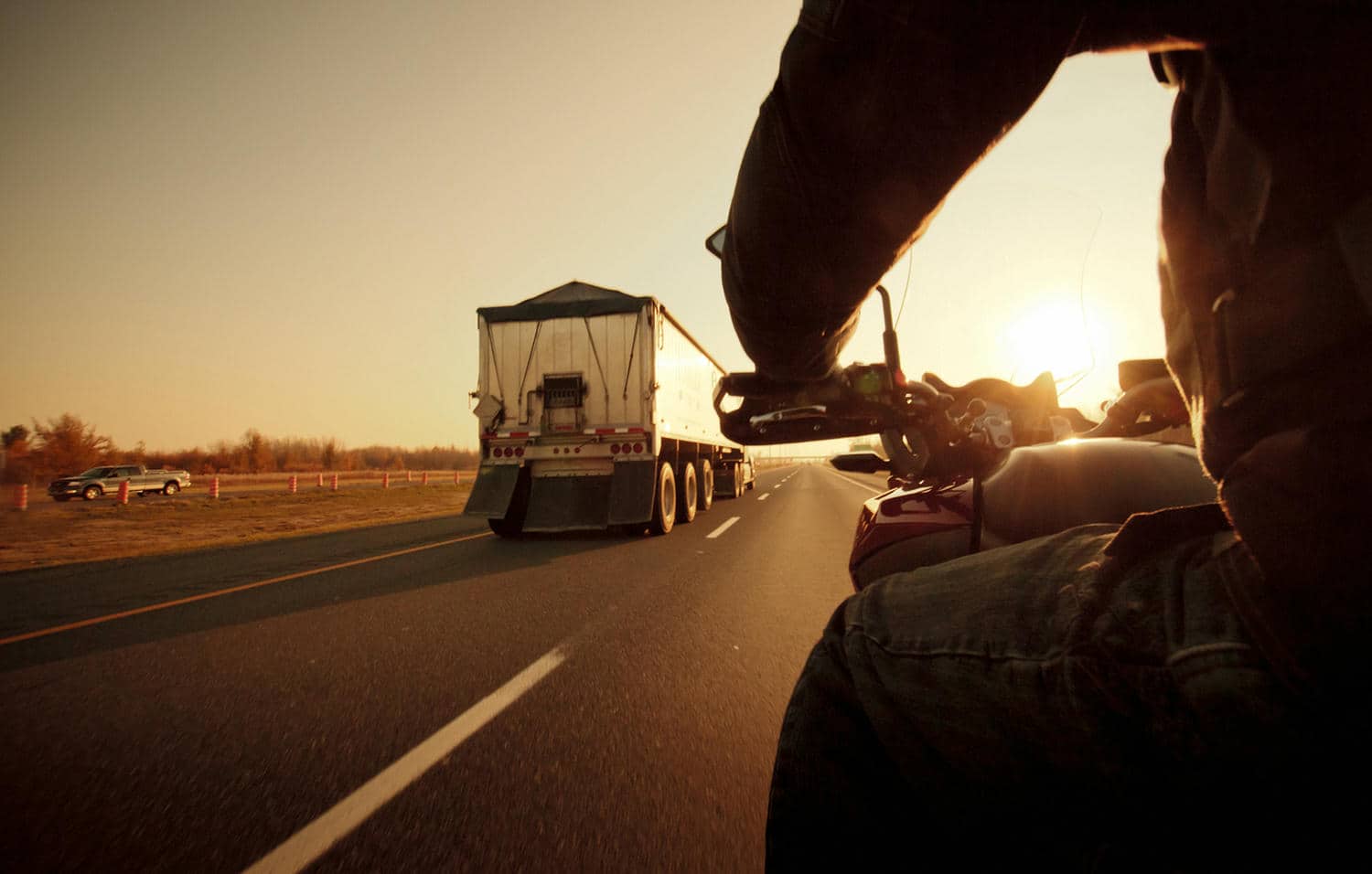 Motorcycle rider on an open road at sunset