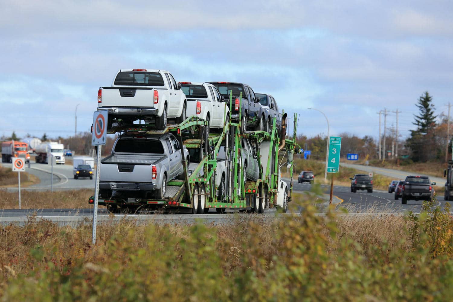 Diverse vehicles being loaded onto a transport truck, illustrating various car shipping methods