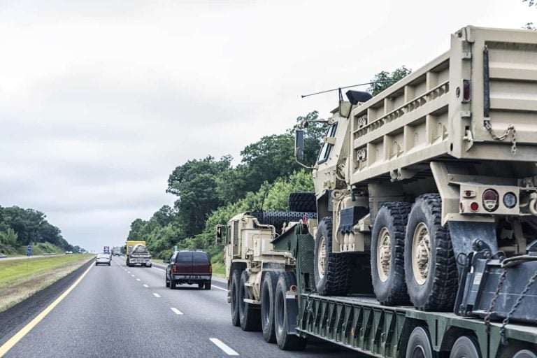 Heavy USA Military Dump Truck Hauled on Flatbed Semi-Truck