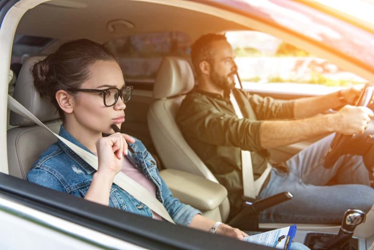male student and female teacher driving in car at driving test