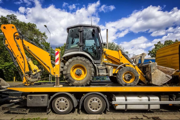 The trailer platform with yellow Backhoe