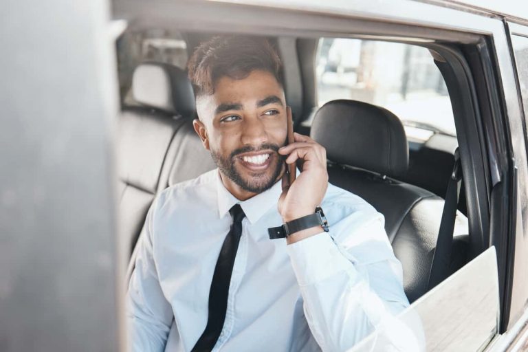 Thinking, happy and businessman on phone call in a car for travel communication and work. Smile, ideas and a young corporate employee in a taxi or transport while speaking on a mobile in the morning