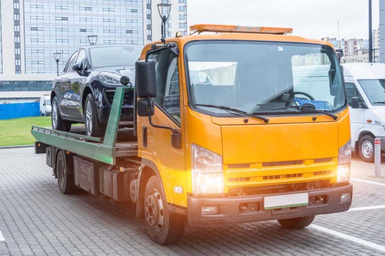 Passenger car loaded onto a recovery truck for transportation.