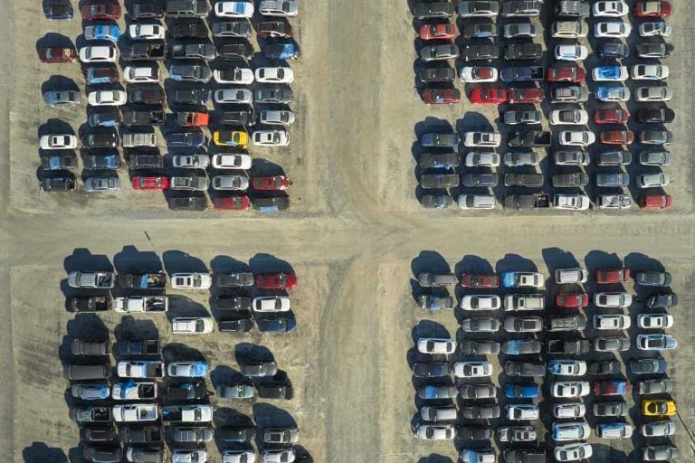 Used damaged cars on auction reseller company big parking lot ready for resale services. Sales of secondhand vehicles for rebuilt or salvage title