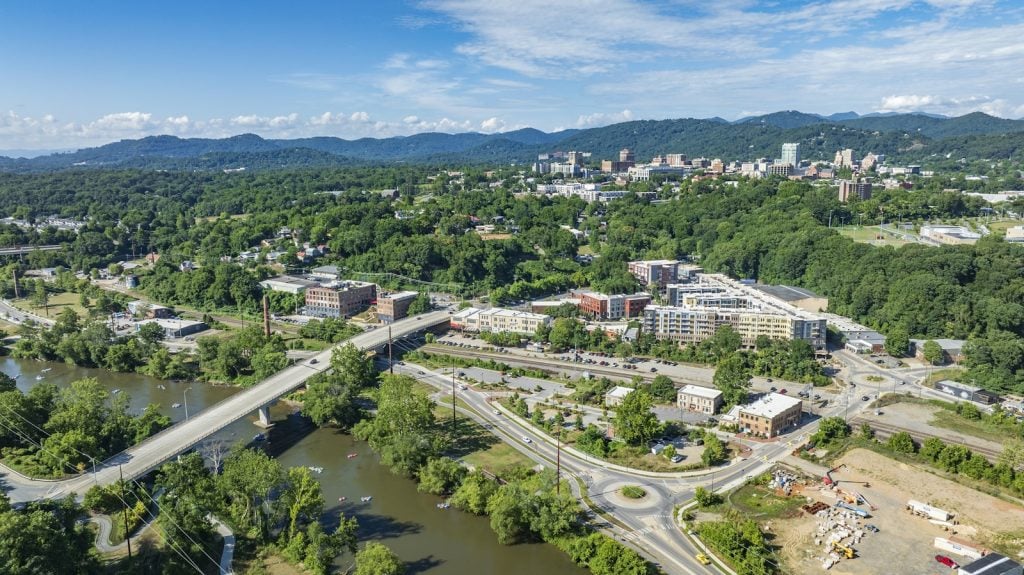 Aerial view of downtown Asheville with the Blue Ridge mountains behind