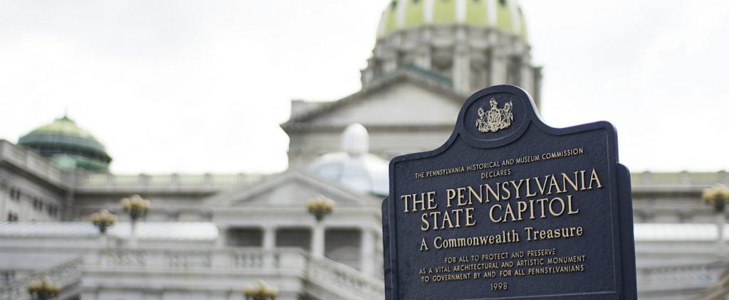 The Pennsylvania State Capitol dome behind its Commonwealth Treasure marker in Harrisburg