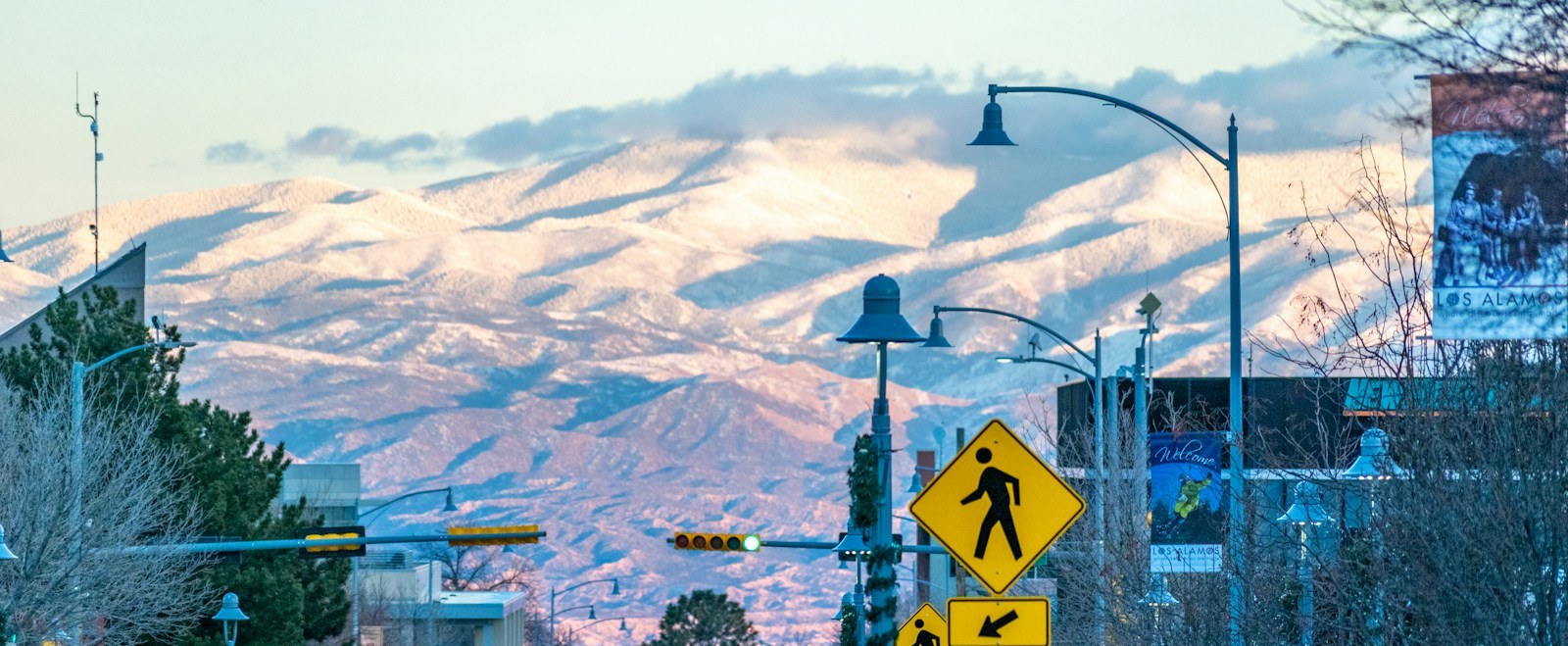 Snow-covered Jemez mountains rising over a downtown Los Alamos street