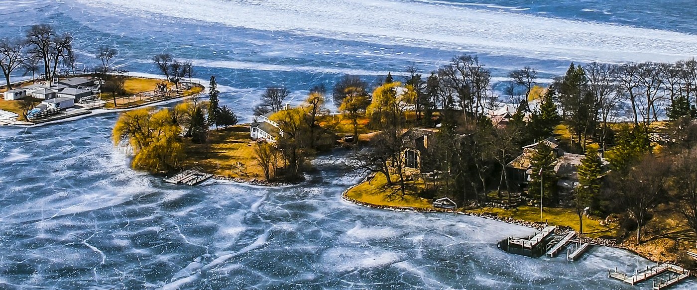 Aerial view of a Lake Minnetonka island shoreline with lakeside homes and docks in early winter