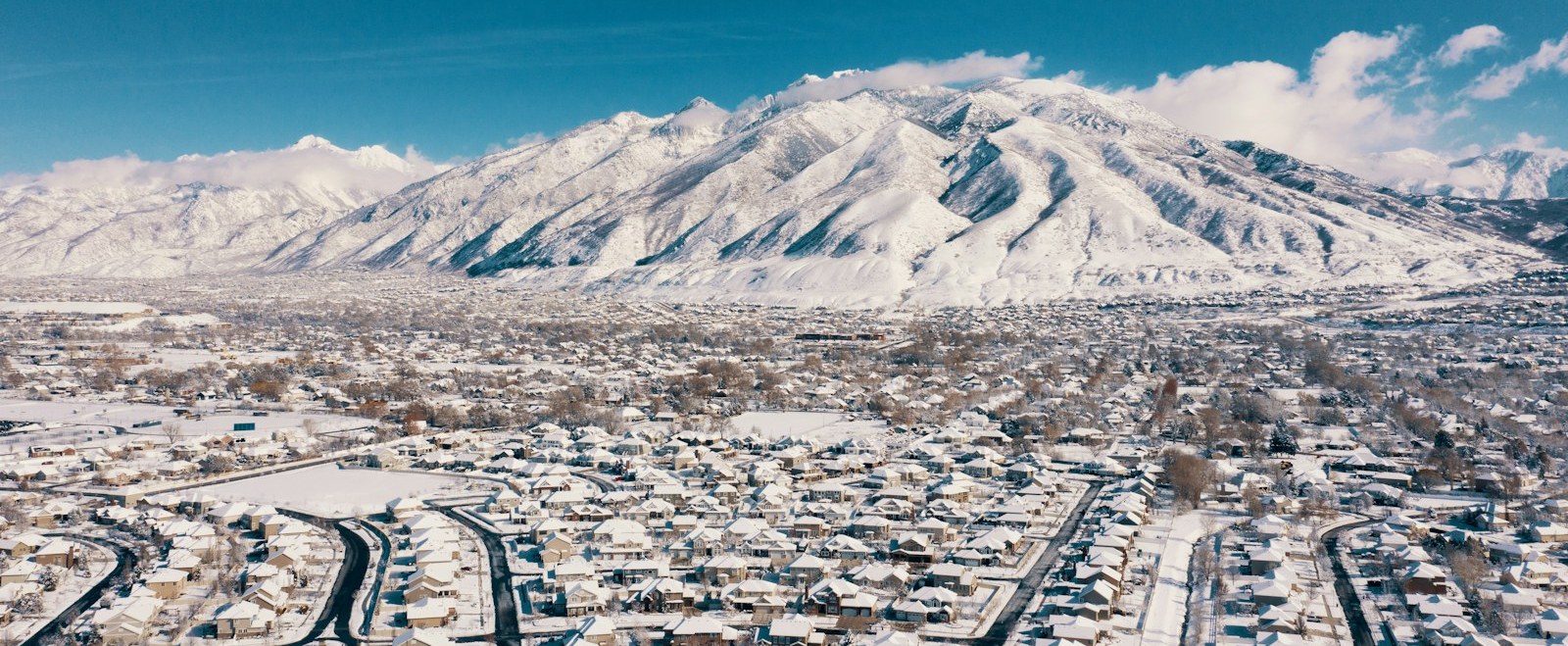 Aerial view of snow-covered Draper neighborhoods beneath the Wasatch mountains in Utah