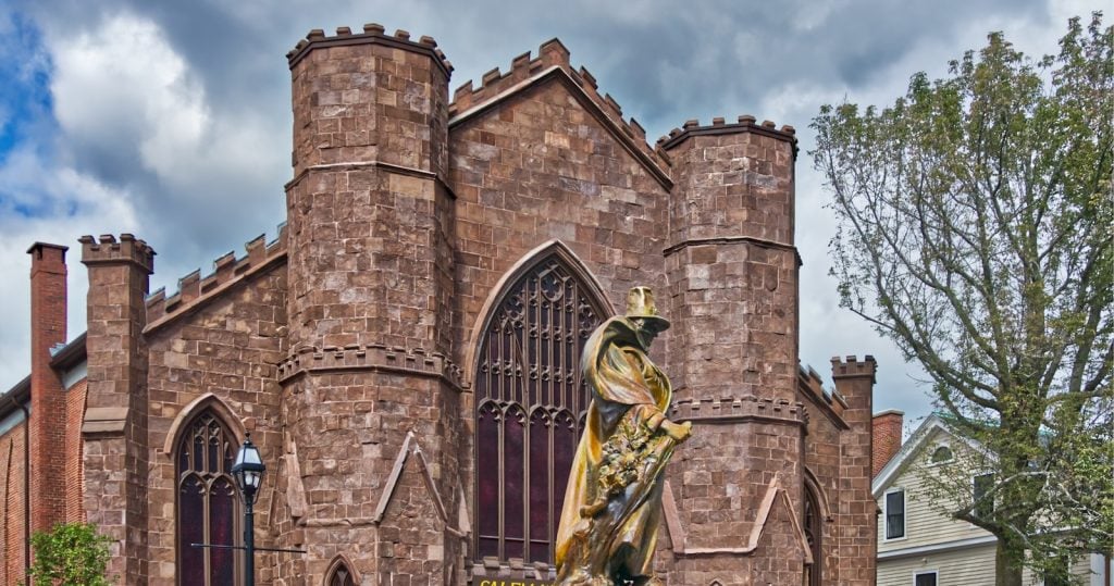 The Salem Witch Museum's stone facade behind the Roger Conant statue in Salem, Massachusetts