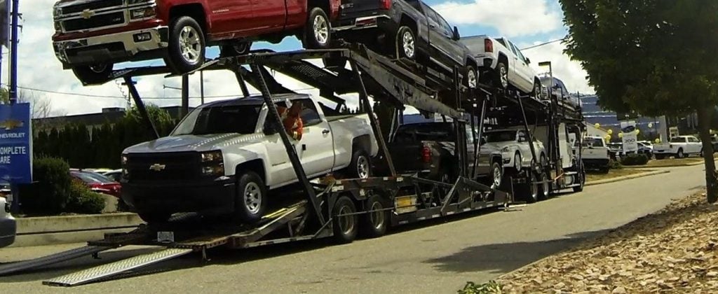 Pickups loaded on an open car carrier