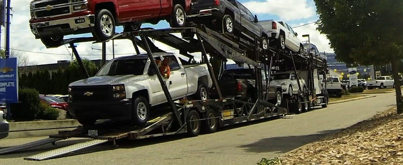 Pickups loaded on an open car carrier