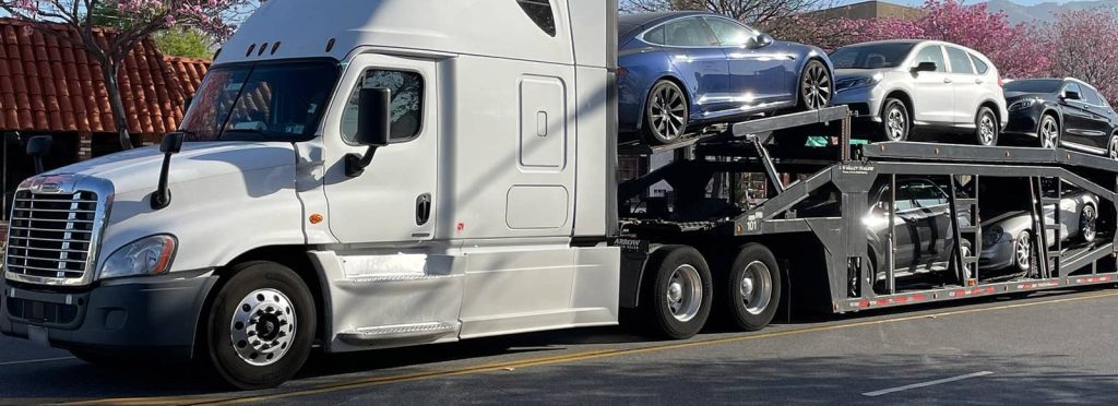 Car carrier loaded with sedans and SUVs