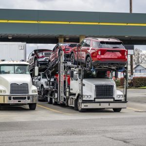 Car hauler semi truck loaded with red SUVs parked at a truck stop