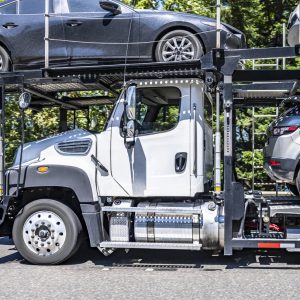 Profile of a day cab car hauler semi truck with cars on a two-level trailer