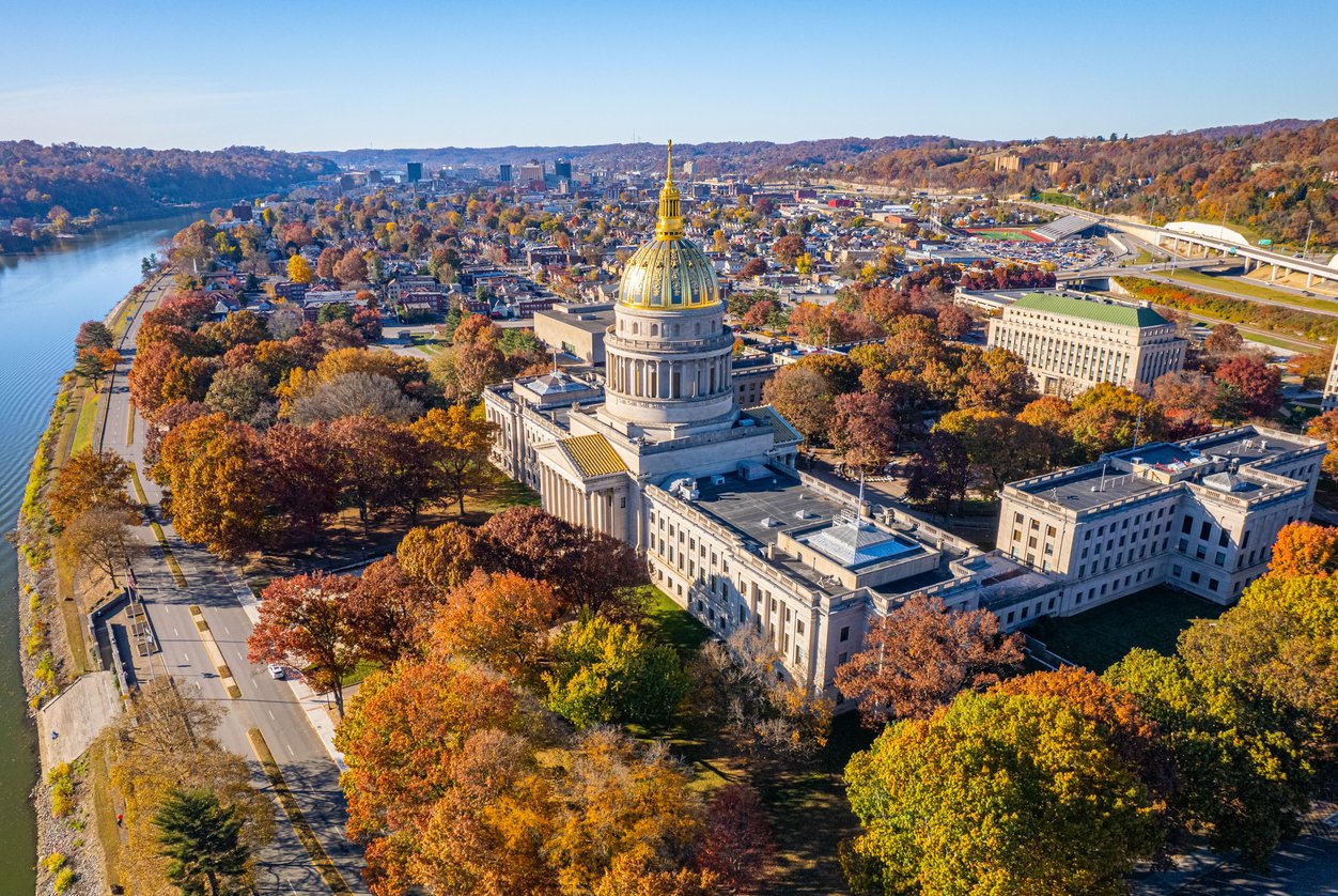 Aerial view of the gold-domed West Virginia State Capitol and downtown Charleston with fall foliage