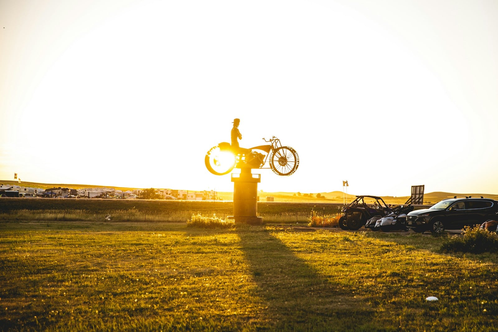Motorcycle rider statue silhouetted at sunset