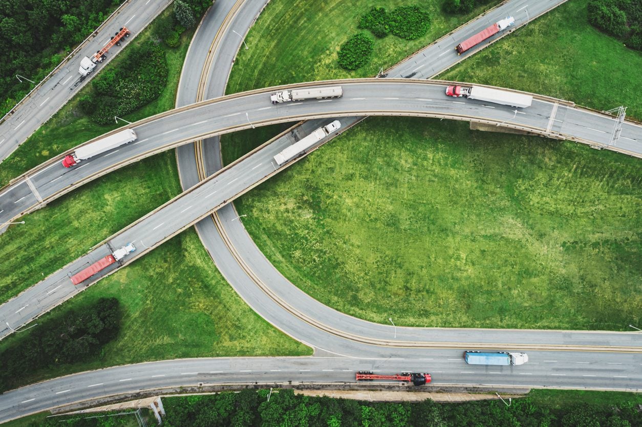 Aerial view of trucks on curving interchange ramps
