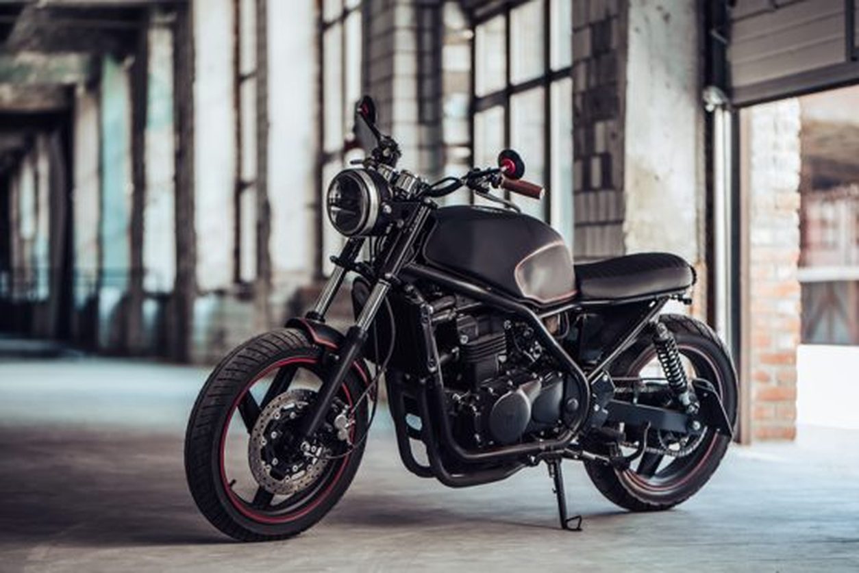 Hand built black bobber style motorcycle in an industrial workshop