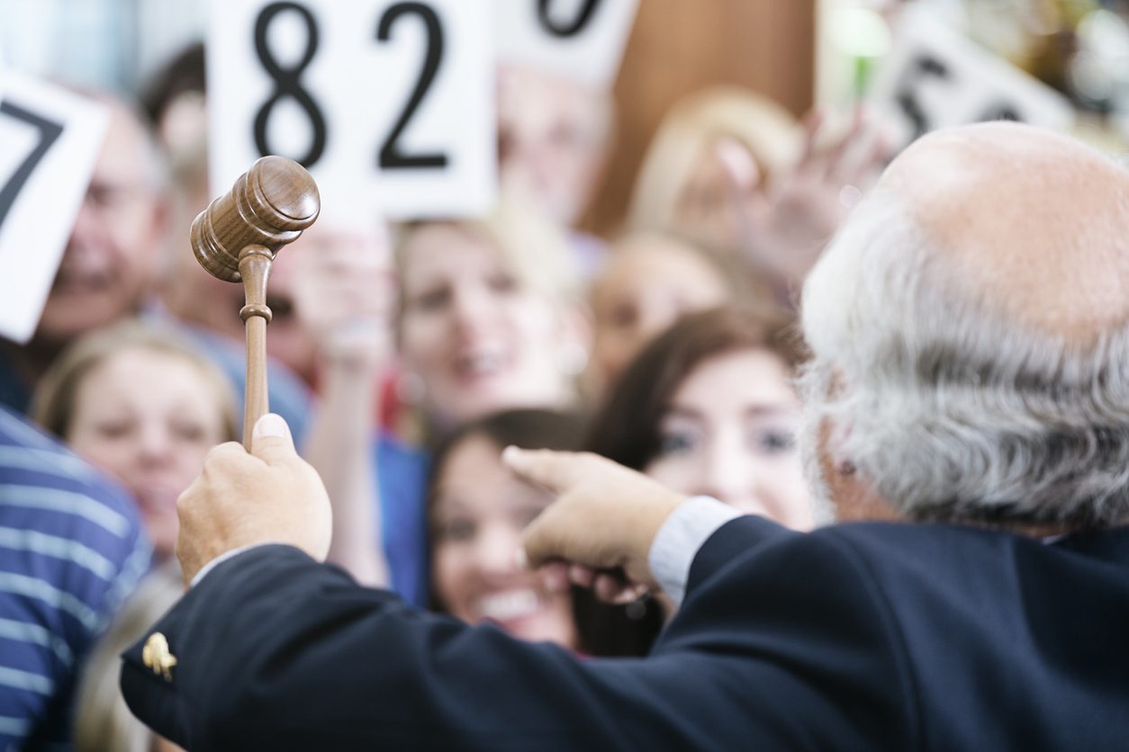 Auctioneer taking bids from a crowd of buyers