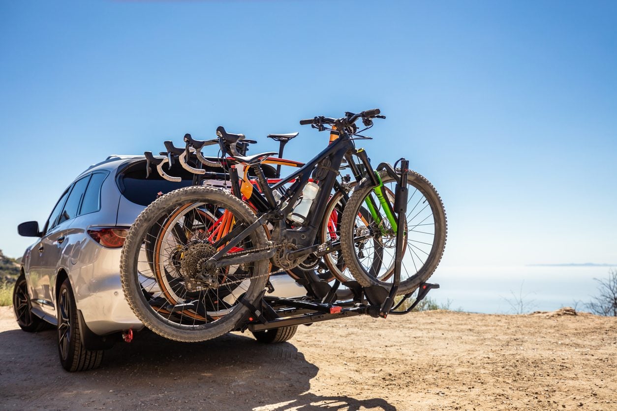 Mountain bikes mounted on a hitch rack behind an SUV