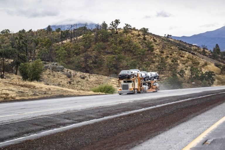 Car hauler on a highway through open country