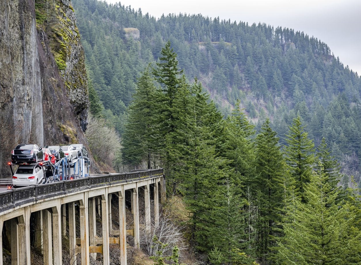 Loaded car hauler crossing a mountain viaduct