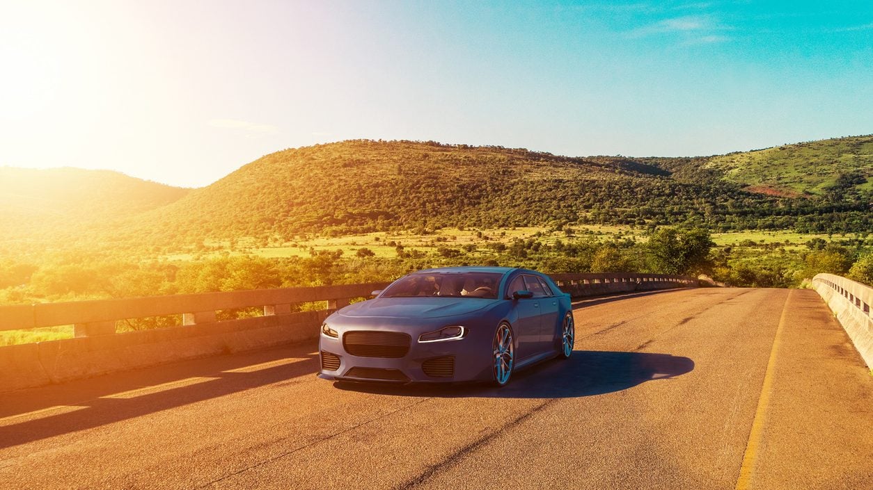 Sedan driving a country road in bright sunshine