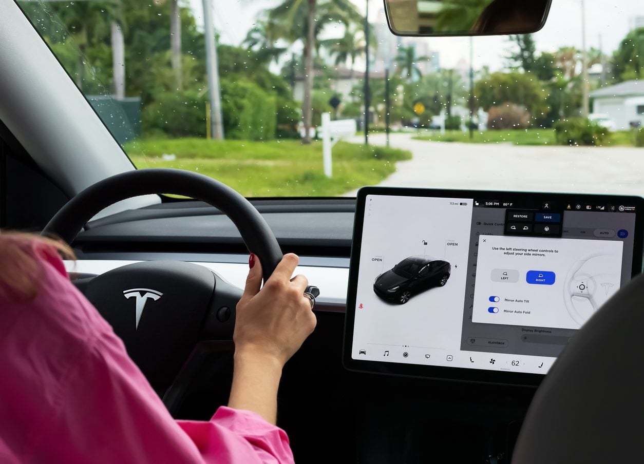 Driver at the wheel beside a large center touchscreen