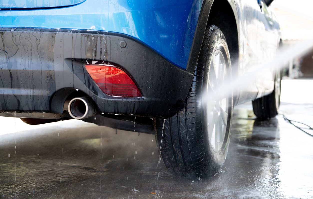 Pressure washing a car wheel and lower body before shipping