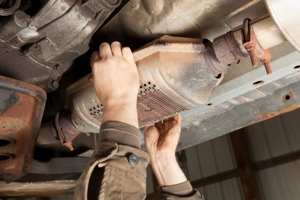 Removing a catalytic converter from a car at a salvage yard
